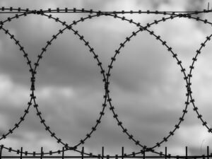 a black and white photo of a barbed wire fence